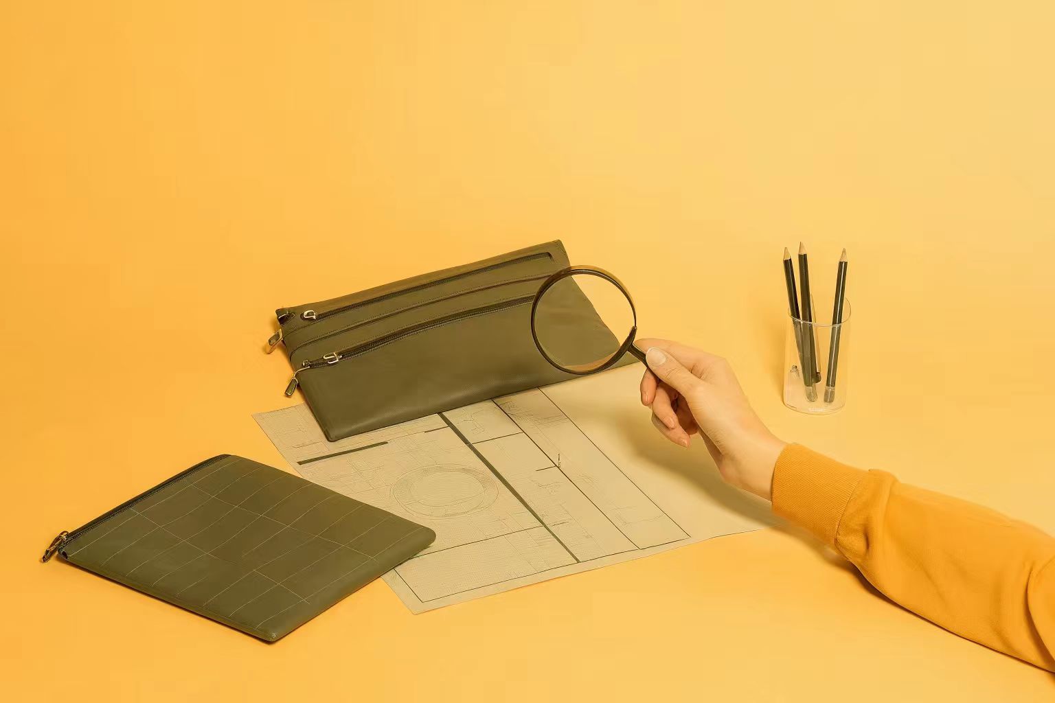 Prototyping and Sampling Process for Makeup Bags A designer carefully examining a physical pre-production sample of a makeup bag against her technical drawings