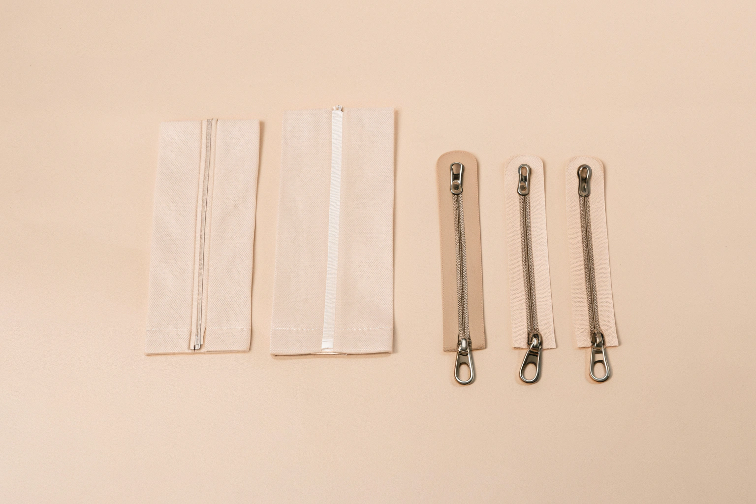 A flat lay of various material swatches like rPET and vegan leather, alongside different metal zippers and custom pulls